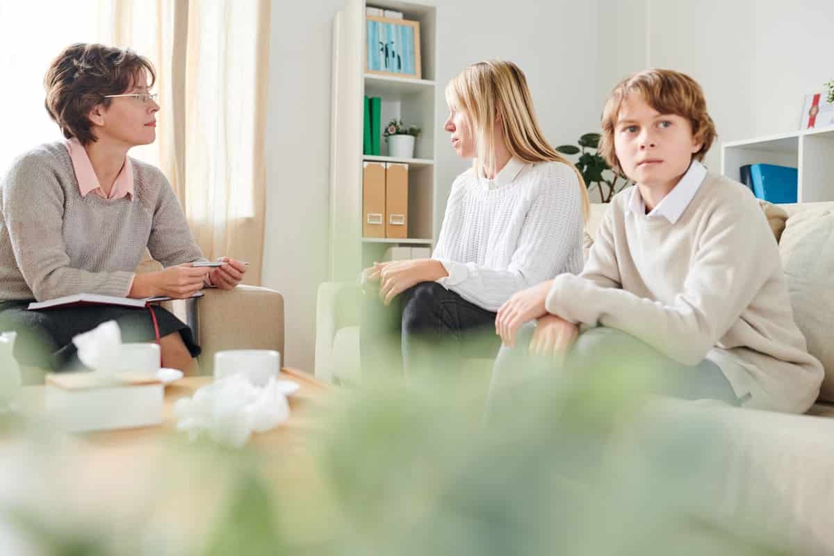Especialista en intervención familiar socioeducativa atendiendo a una familia en una sesión de mediación sistémica.