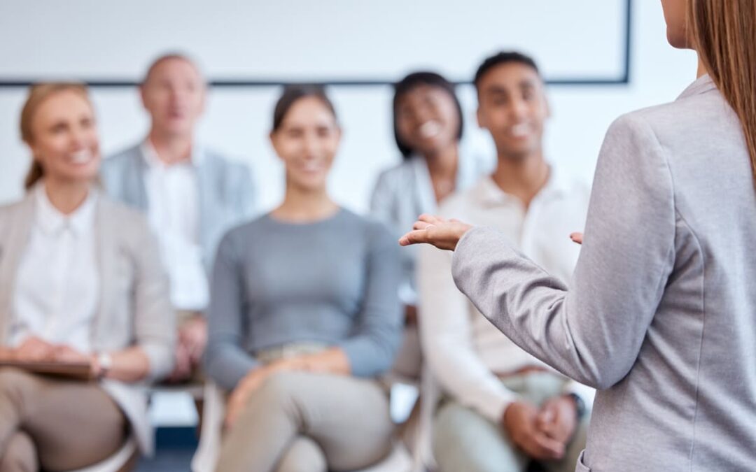 Profesional formada en coaching emocional dirigiendo una sesión de formación y desarrollo personal ante un grupo.