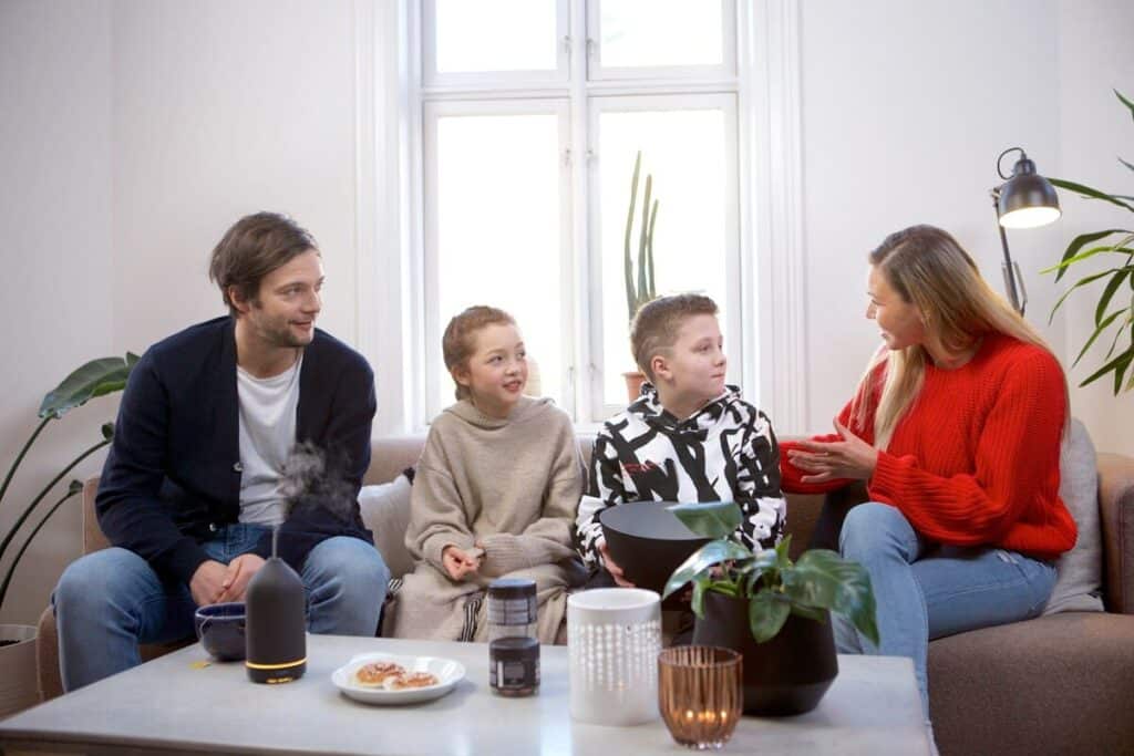 Familia con dos hijos participando en una sesión de mediación e intervención familiar en un entorno acogedor.